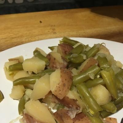 haricots verts frais cuits lentement avec du bacon, de l'oignon et des pommes de terre rouges
