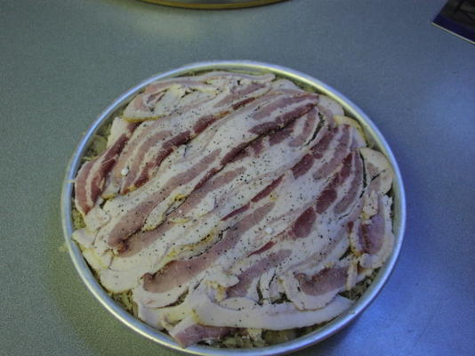 bratwurst et couche de bacon cuits au four avec une couche de choucroute