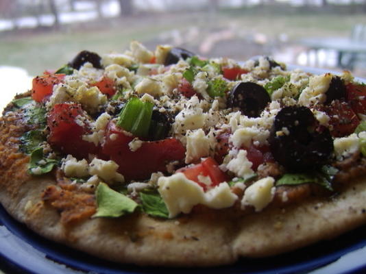 pita pizzas avec houmous, épinards, olives, tomates et fromage