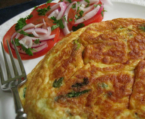 frittata aux asperges et fontina avec tranches de tomate et d'oignon rouge