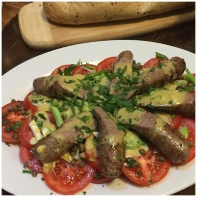 saucisses toulouse chaudes avec une salade de tomates, câpres et échalotes